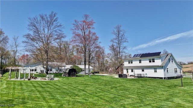 view of green lawn with a storage unit, a pergola, an outbuilding, and a patio area