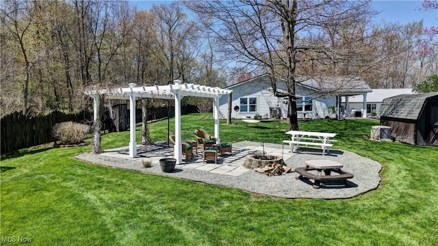 view of grassy yard featuring a fire pit, a pergola, a patio, an outbuilding, and a storage shed