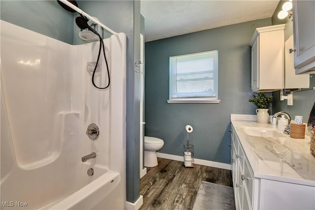 full bath with wood finished floors, toilet, vanity, baseboards, and shower / bathtub combination