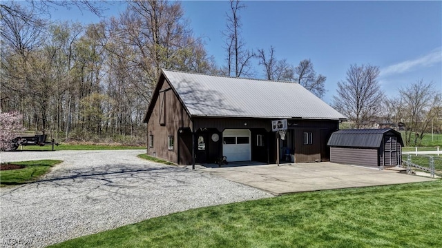 detached garage featuring driveway and a shed