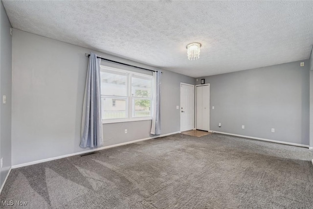 unfurnished room featuring carpet, baseboards, and a textured ceiling