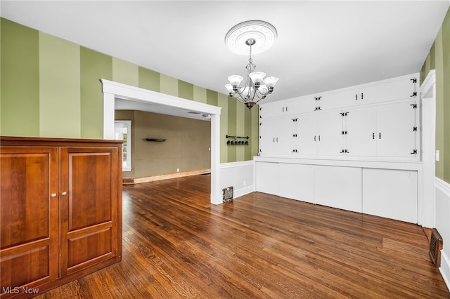 26561 Butternut Ridge Rd, North Olmsted, OH 44070 - unfurnished dining area featuring a chandelier, dark wood-type flooring, and a wainscoted wall