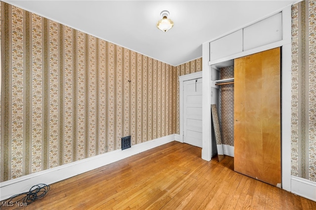 26561 Butternut Ridge Rd, North Olmsted, OH 44070 - unfurnished bedroom with hardwood / wood-style flooring, wallpapered walls, a closet, and baseboards