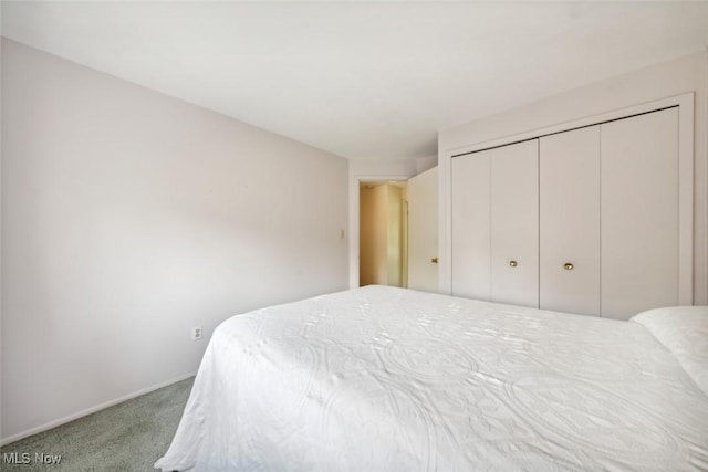 carpeted bedroom with baseboards and a closet