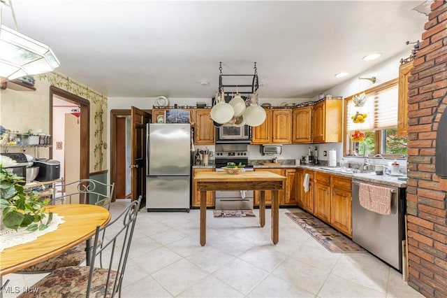 73 Hemlock Ln, Weirton, WV 26062 - kitchen with stainless steel appliances, a sink, brown cabinetry, light countertops, and light tile patterned flooring