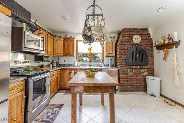 73 Hemlock Ln, Weirton, WV 26062 - kitchen with stainless steel appliances, a sink, brown cabinets, and a chandelier