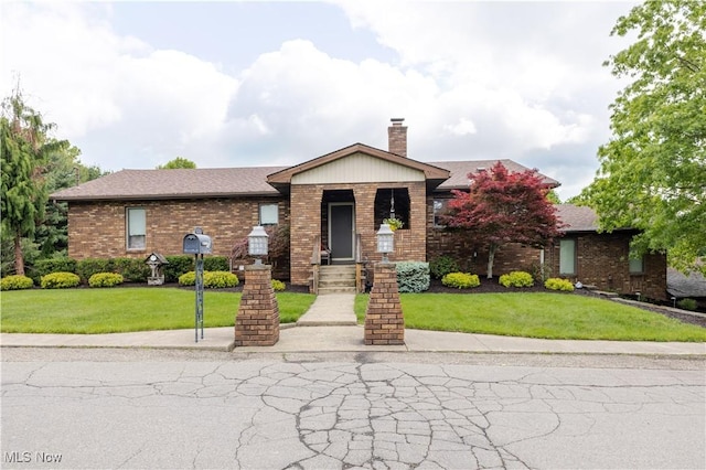 73 Hemlock Ln, Weirton, WV 26062 - view of front of house featuring brick siding, a front lawn, and a chimney