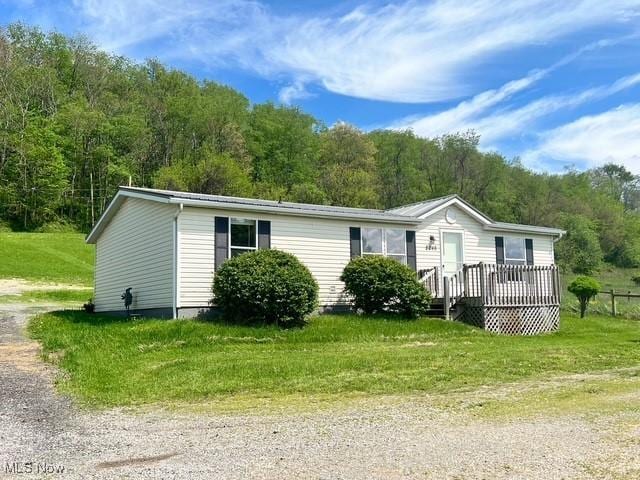 8248 Lappin Ln NE, Mineral City, OH 44656 - manufactured / mobile home featuring driveway, a forest view, a wooden deck, and a front lawn