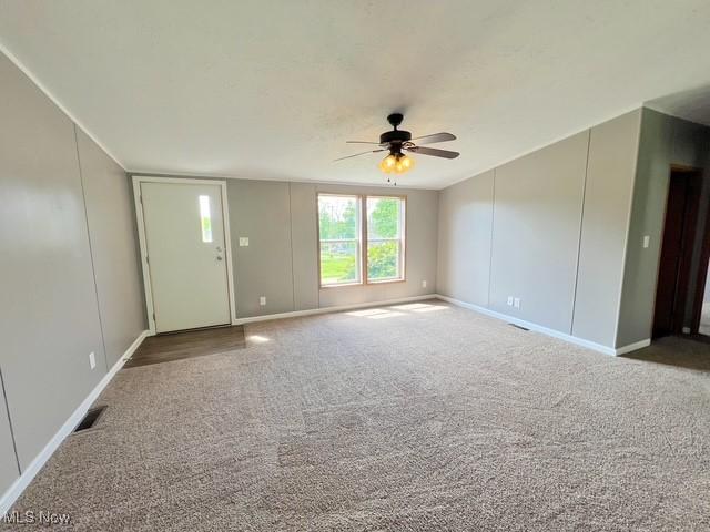 8248 Lappin Ln NE, Mineral City, OH 44656 - unfurnished living room featuring a ceiling fan, carpet, and baseboards