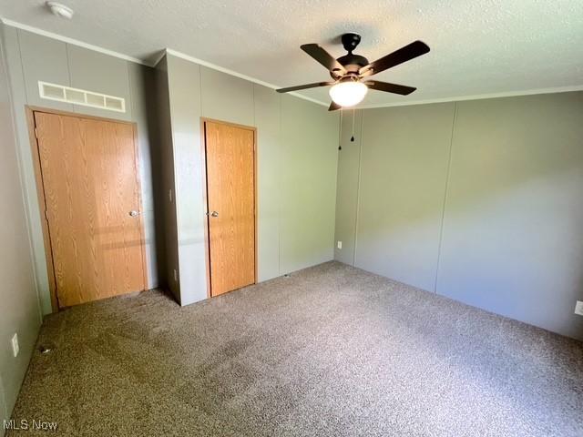 8248 Lappin Ln NE, Mineral City, OH 44656 - unfurnished bedroom with crown molding, carpet floors, a ceiling fan, a closet, and a textured ceiling