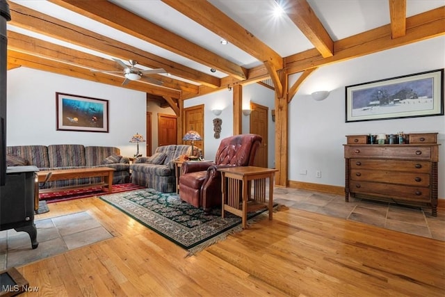 70 Northlake Ct, Vincent, OH 45784 - living room with beamed ceiling, a ceiling fan, hardwood / wood-style flooring, a wood stove, and baseboards