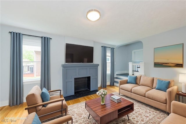 living room with light wood-style flooring and a fireplace with flush hearth