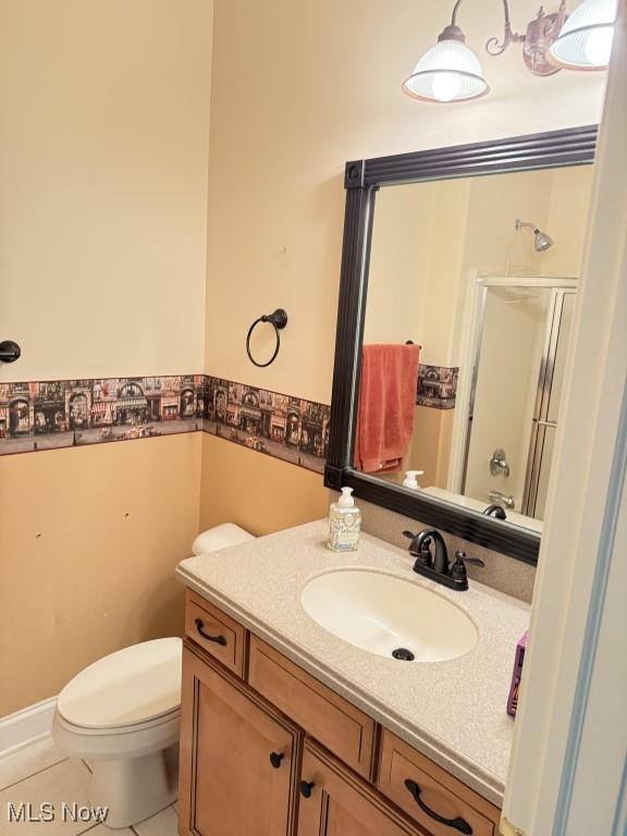 bathroom with a shower stall, toilet, and vanity