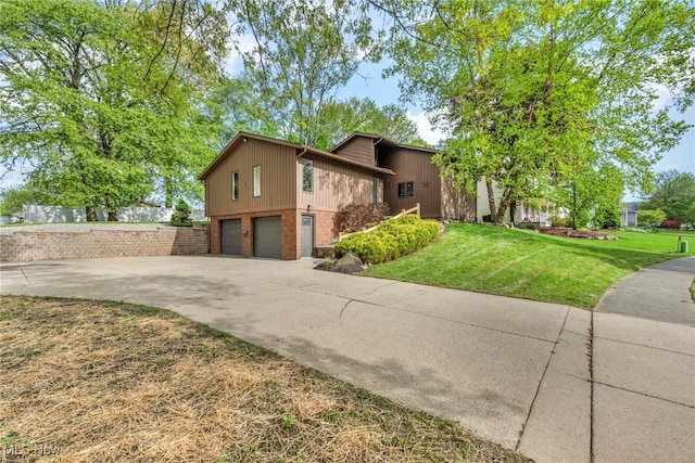 view of home's exterior with brick siding, an attached garage, concrete driveway, and a yard