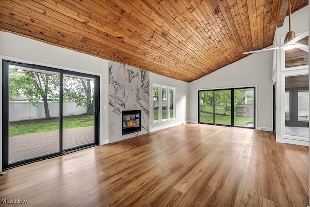 unfurnished living room with a fireplace, wood finished floors, baseboards, high vaulted ceiling, and wooden ceiling