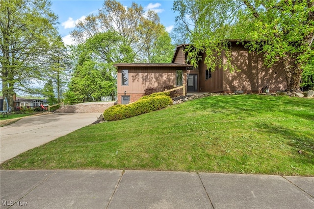view of front facade featuring a front yard and concrete driveway