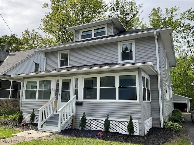 traditional style home with a sunroom, entry steps, and a shingled roof