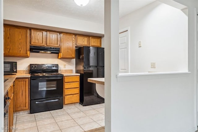 1328 Cedarwood Dr Unit A3, Westlake, OH 44145 - kitchen featuring black appliances, under cabinet range hood, brown cabinets, light countertops, and light tile patterned floors