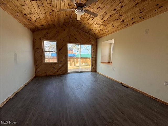 empty room with wooden walls, dark wood-style flooring, vaulted ceiling, baseboards, and ceiling fan