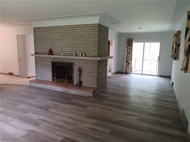 1050 Park Cir, Girard, OH 44420 - unfurnished living room featuring a brick fireplace, baseboards, and wood finished floors