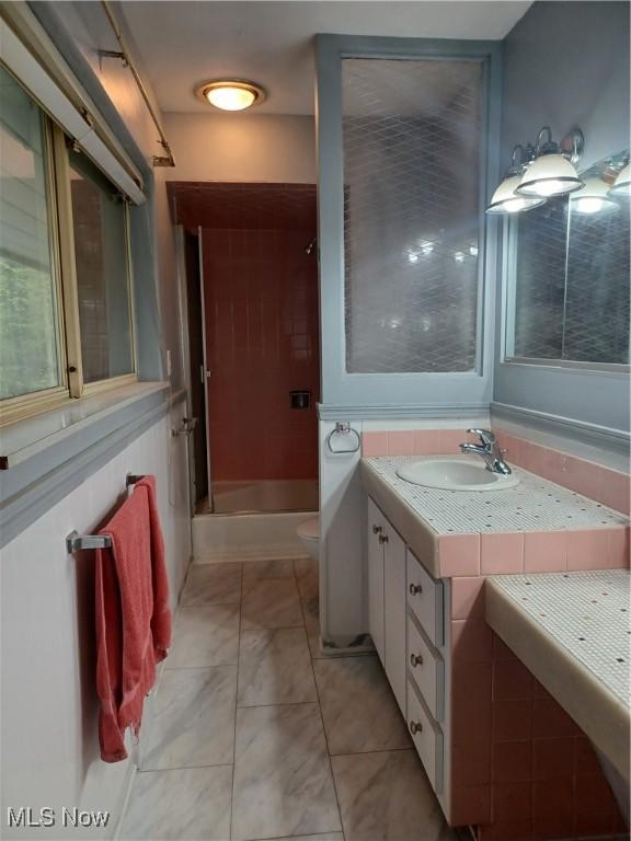 1050 Park Cir, Girard, OH 44420 - full bathroom with vanity, toilet, marble look tiles, and shower / bath combination