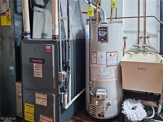 utilities featuring gas water heater, heating unit, and a sink