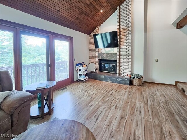 living area featuring lofted ceiling, wood finished floors, a brick fireplace, baseboards, and wooden ceiling