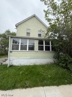 rear view of property featuring a sunroom