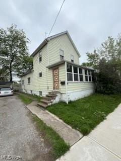 view of front of house featuring asphalt driveway and a front lawn