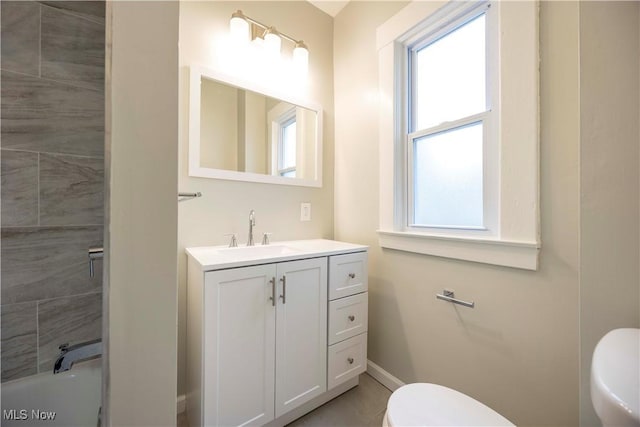 bathroom featuring toilet, baseboards, and vanity