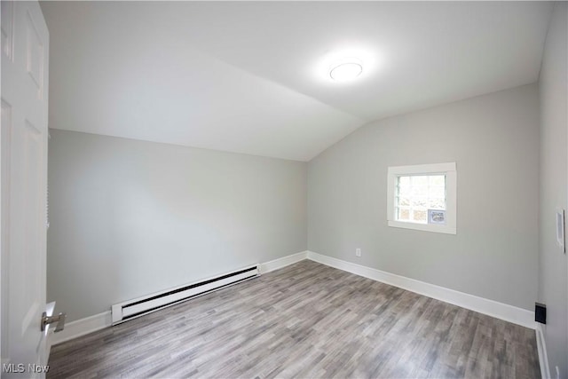 additional living space featuring baseboard heating, lofted ceiling, wood finished floors, and baseboards