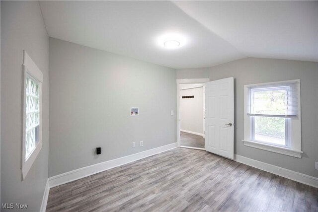 additional living space featuring wood finished floors, lofted ceiling, and baseboards