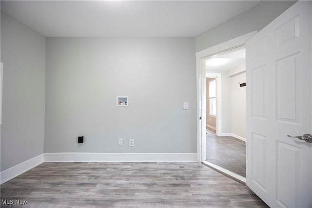 spare room featuring baseboards and wood finished floors