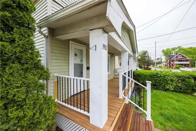 property entrance featuring covered porch and a yard