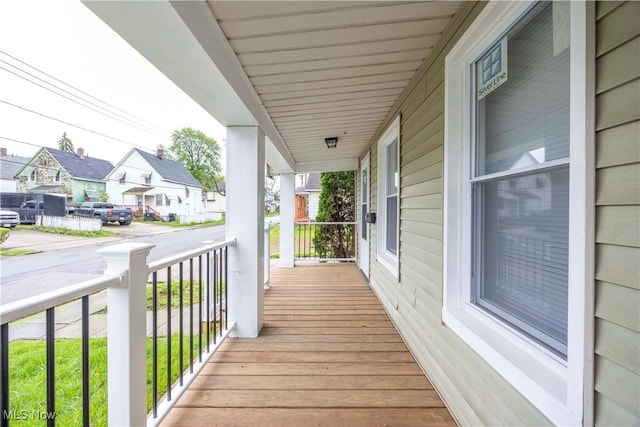 wooden deck featuring covered porch and a residential view