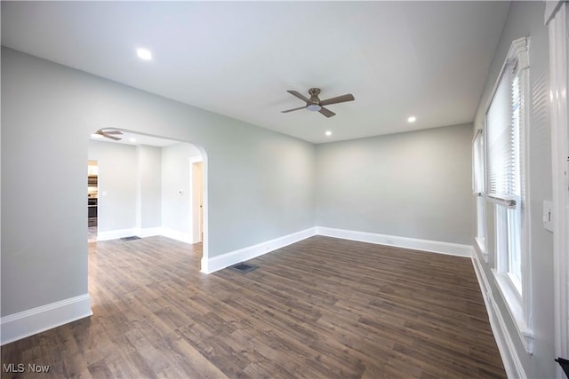 unfurnished room with a ceiling fan, arched walkways, dark wood-style flooring, baseboards, and recessed lighting