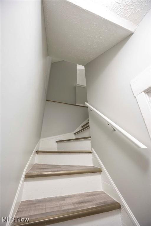 staircase featuring baseboards
