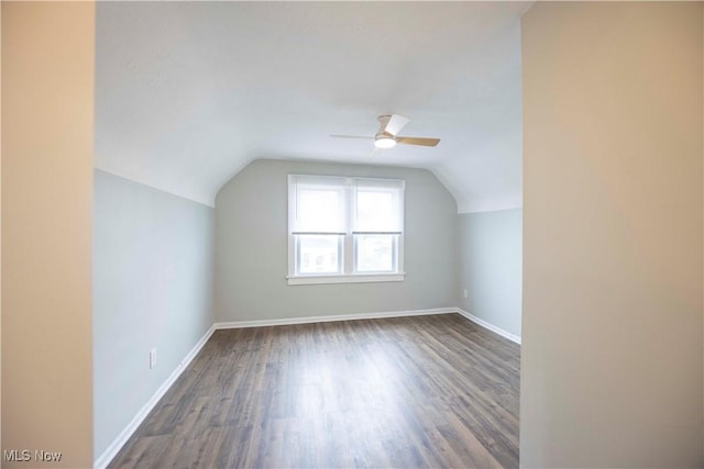 additional living space featuring wood finished floors, a ceiling fan, vaulted ceiling, and baseboards