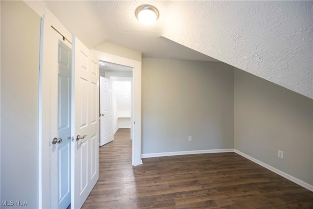3982 E 74th St, Cleveland, OH 44105 - additional living space featuring baseboards, dark wood-style flooring, lofted ceiling, and a textured ceiling