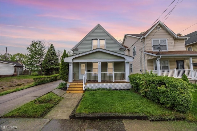 view of front of house featuring covered porch, a front yard, and concrete driveway