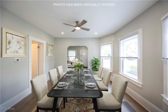 dining space featuring arched walkways, baseboards, a ceiling fan, dark wood-type flooring, and recessed lighting
