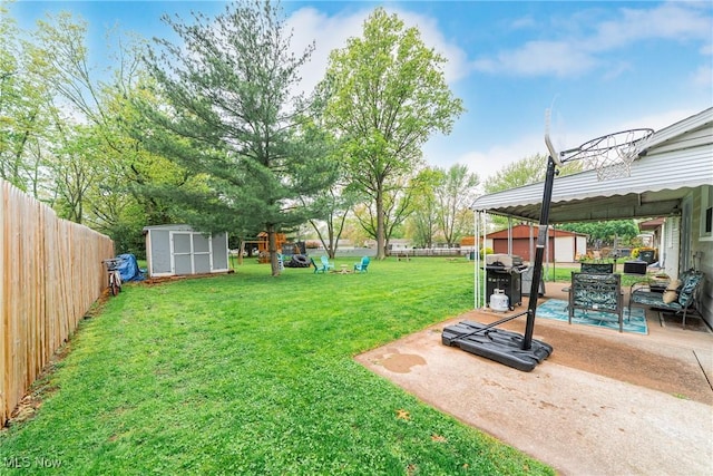 view of yard featuring a shed, an outdoor structure, and a patio