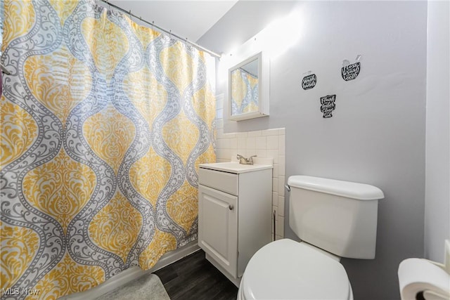 full bathroom with toilet, vanity, tile walls, wood finished floors, and curtained shower