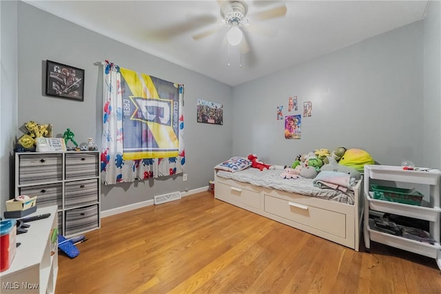 bedroom featuring light wood-style floors, a ceiling fan, and baseboards