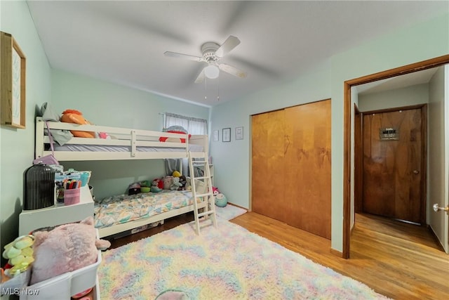 bedroom with wood finished floors, ceiling fan, and a closet