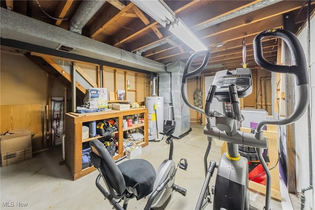 exercise room with gas water heater, heating unit, and a workshop area