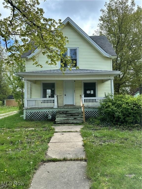 bungalow-style house with covered porch, a front yard, and a shingled roof