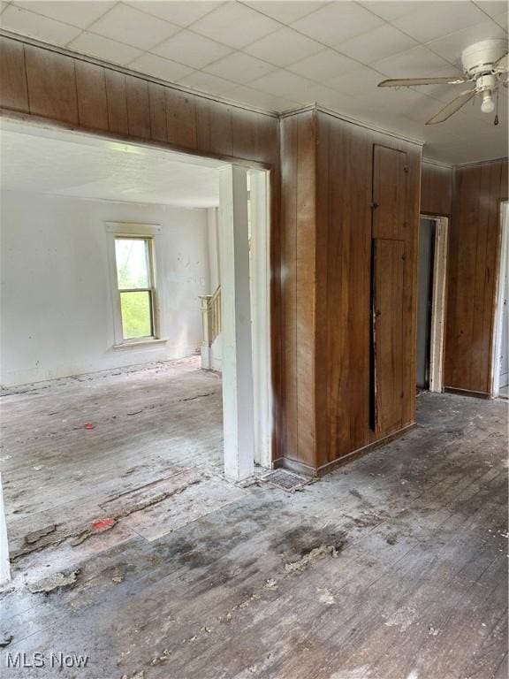 spare room featuring ceiling fan, wood walls, and hardwood / wood-style flooring