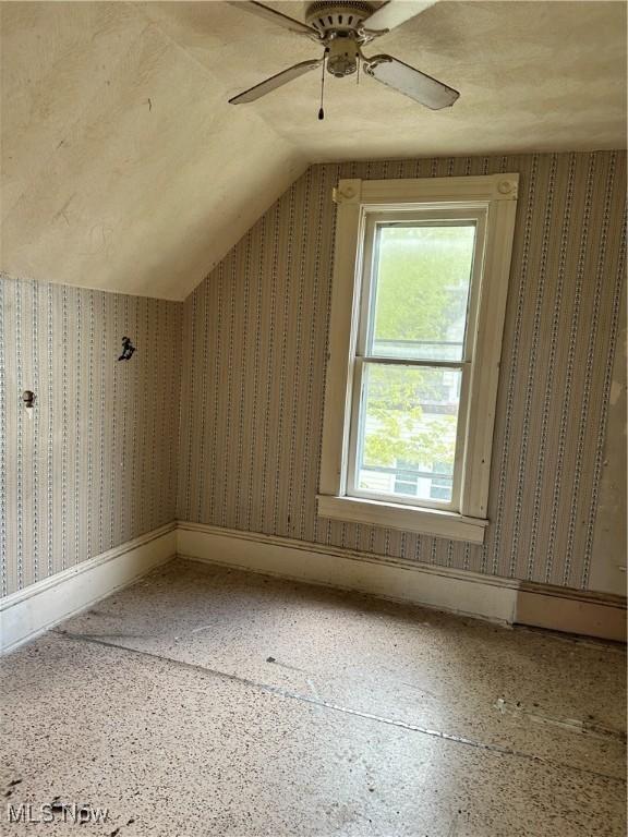 additional living space featuring ceiling fan and lofted ceiling