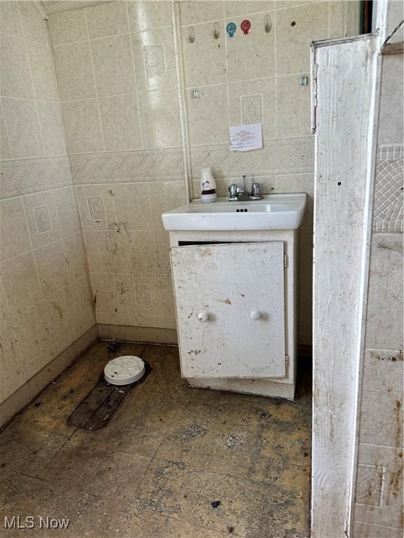 bathroom featuring vanity and tile walls